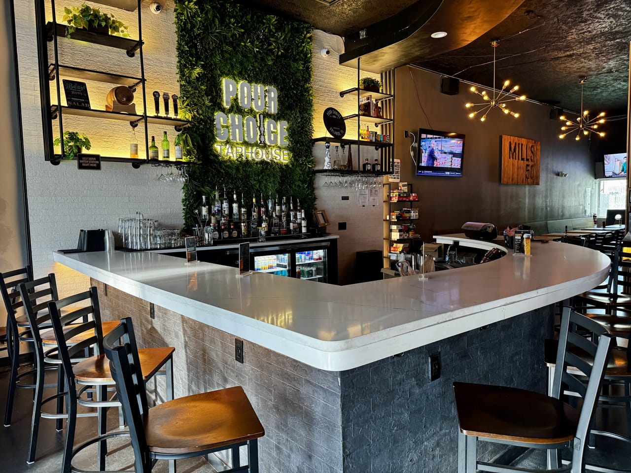 Pour Choice Taphouse interior in Mills 50 Orlando: white marble bar, living plant wall, and neon POUR CHOICE TAPHOUSE sign