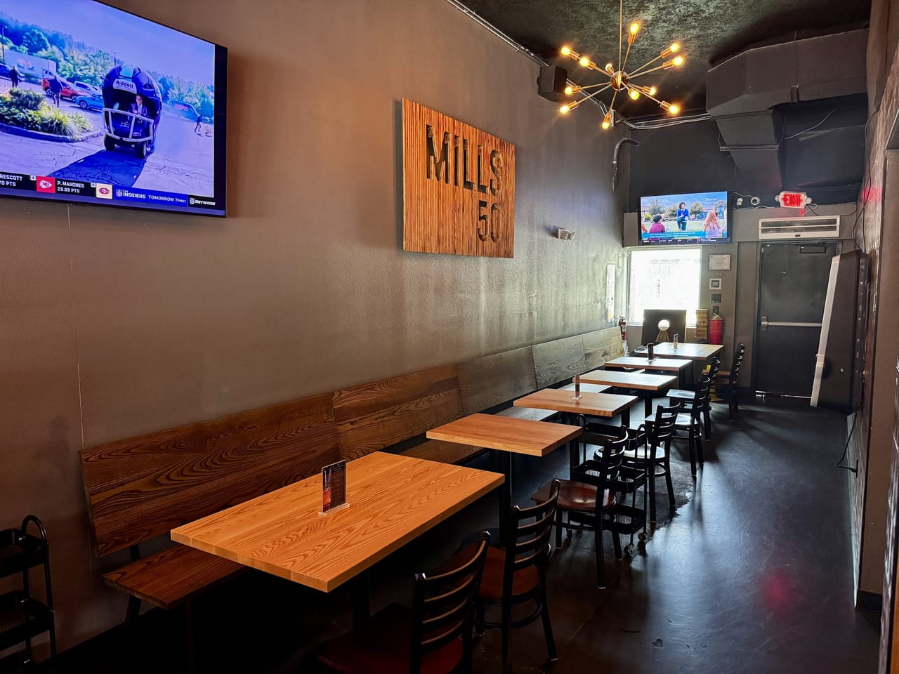 Booth and bench seating corridor with a Mills 50 wood sign at Pour Choice Taphouse in Orlando