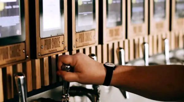 Guest using RFID wristband to pour craft beer from self-serve taps at Pour Choice Taphouse in Orlando's Mills 50 District